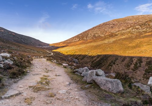 Hiking on winding trail in the valley between Slieve Donard and Rocky Mountain in Mourne Mountains, County Down, Northern Ireland